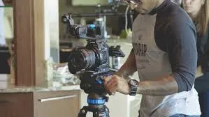 شخص يصور مشهدًا بكاميرا فيديو على حامل